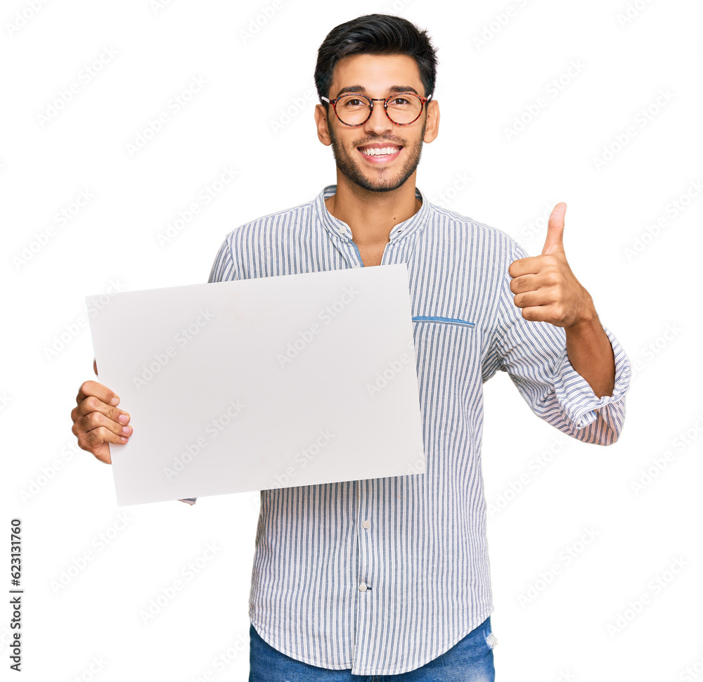 Young handsome man holding blank empty banner smiling happy and positive, thumb up doing excellent and approval sign Young handsome man holding blank empty banner smiling happy and positive, thumb up doing excellent and approval sign