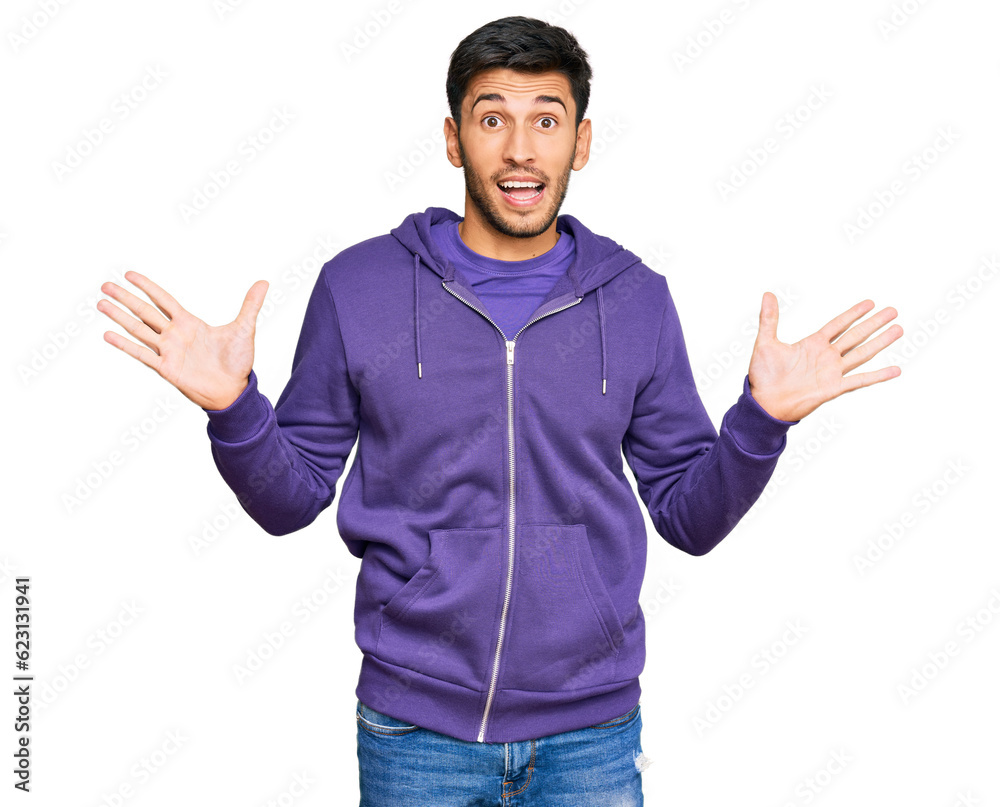 Young handsome man wearing casual sweatshirt celebrating victory with happy smile and winner expression with raised hands Young handsome man wearing casual sweatshirt celebrating victory with happy smile and winner expression with raised hands