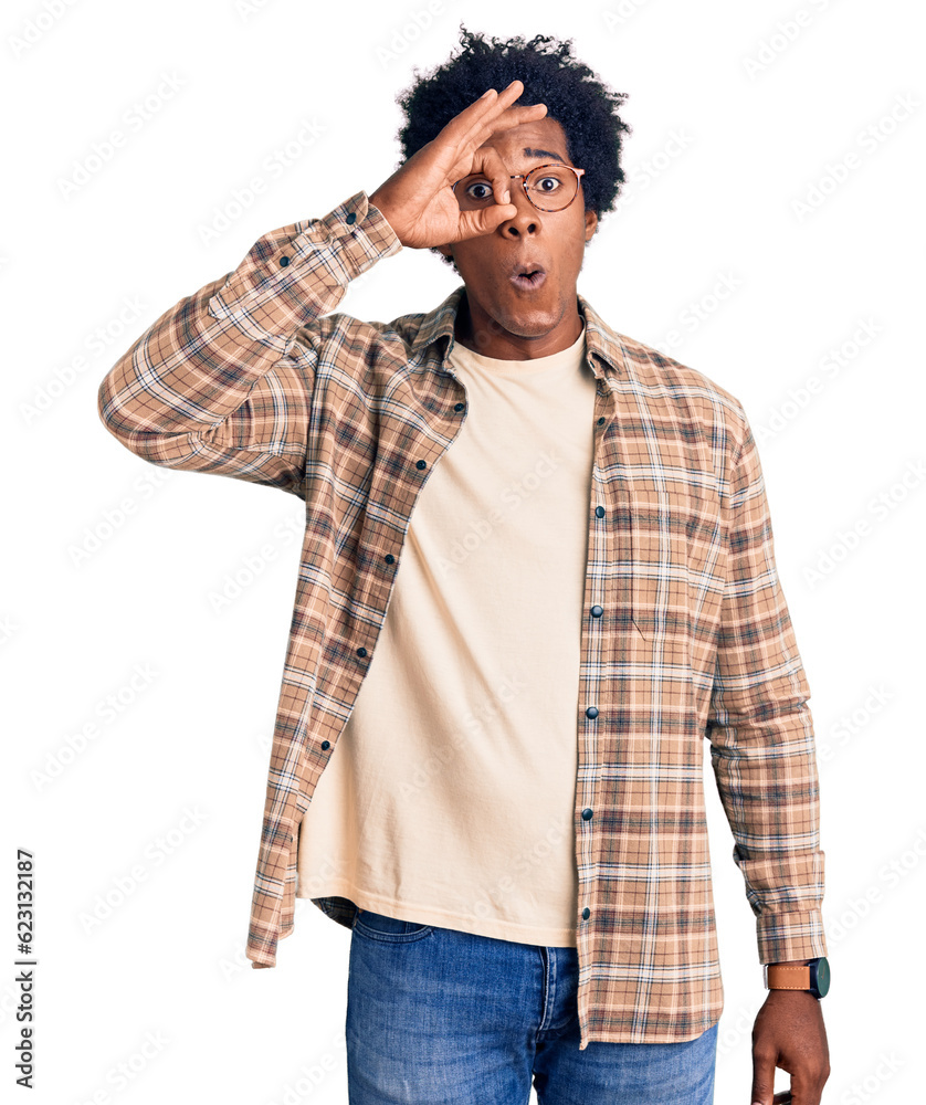 Handsome african american man with afro hair wearing casual clothes and glasses doing ok gesture shocked with surprised face, eye looking through fingers. unbelieving expression. Handsome african american man with afro hair wearing casual clothes and glasses doing ok gesture shocked with surprised face, eye looking through fingers. unbelieving expression.