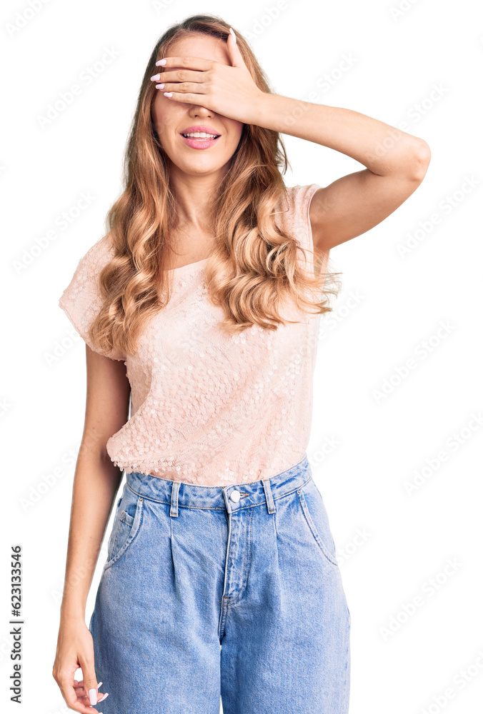 Young beautiful caucasian woman with blond hair wearing casual clothes smiling and laughing with hand on face covering eyes for surprise. blind concept. Young beautiful caucasian woman with blond hair wearing casual clothes smiling and laughing with hand on face covering eyes for surprise. blind concept.