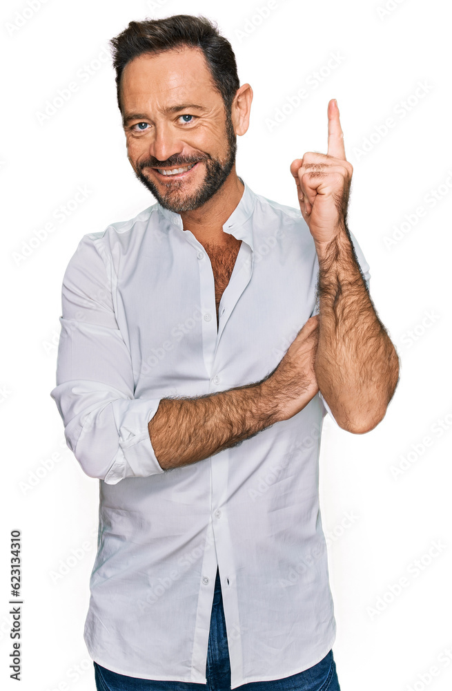 Middle age man wearing casual clothes with a big smile on face, pointing with hand and finger to the side looking at the camera. Middle age man wearing casual clothes with a big smile on face, pointing with hand and finger to the side looking at the camera.