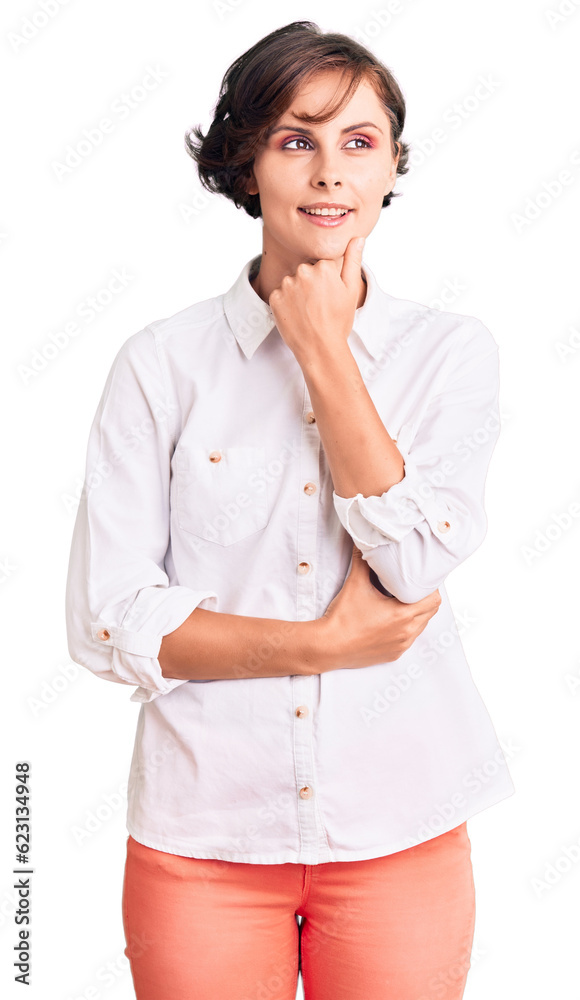 Beautiful young woman with short hair wearing elegant white shirt with hand on chin thinking about question, pensive expression. smiling with thoughtful face. doubt concept. Beautiful young woman with short hair wearing elegant white shirt with hand on chin thinking about question, pensive expression. smiling with thoughtful face. doubt concept.