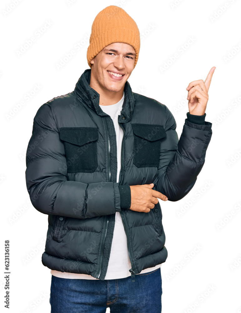 Handsome caucasian man wearing snow wear smiling happy pointing with hand and finger to the side Handsome caucasian man wearing snow wear smiling happy pointing with hand and finger to the side