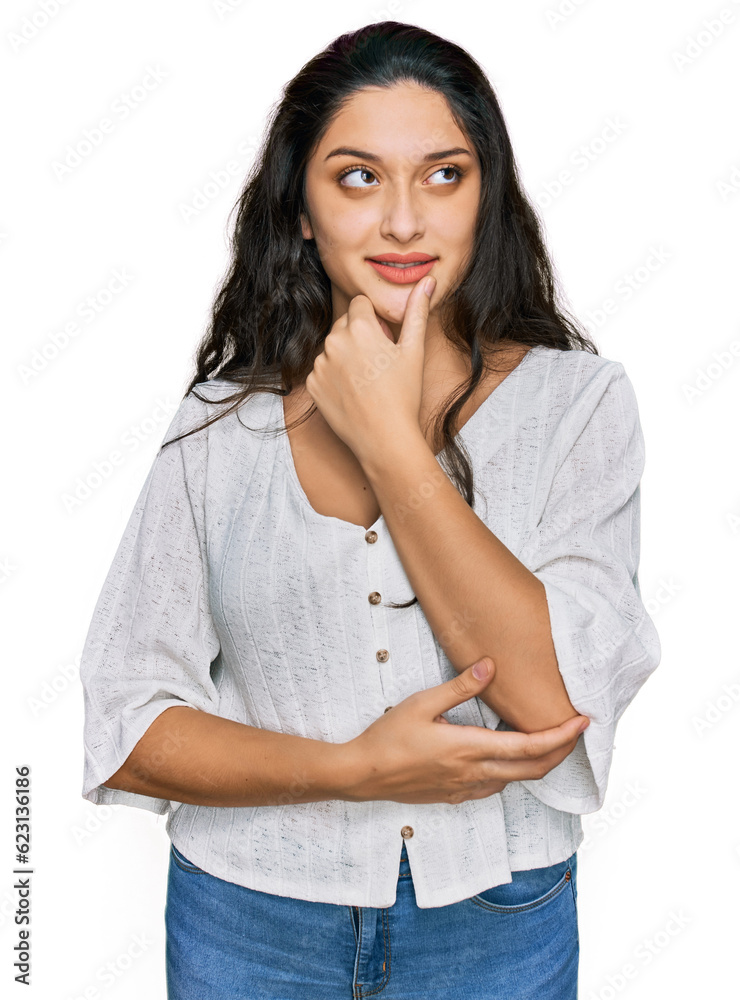 Brunette young woman wearing casual clothes with hand on chin thinking about question, pensive expression. smiling with thoughtful face. doubt concept. Brunette young woman wearing casual clothes with hand on chin thinking about question, pensive expression. smiling with thoughtful face. doubt concept.