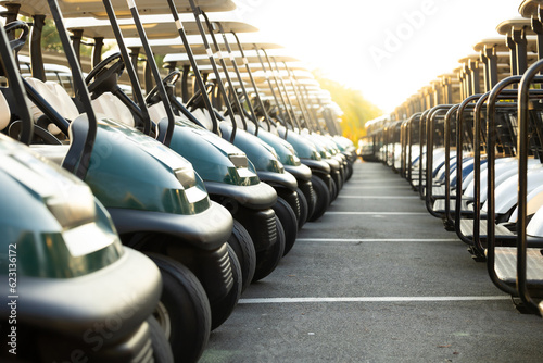 Many golf carts for golf player on a golf course. golf course carts cars at luxury resort sport venue in neat line row.