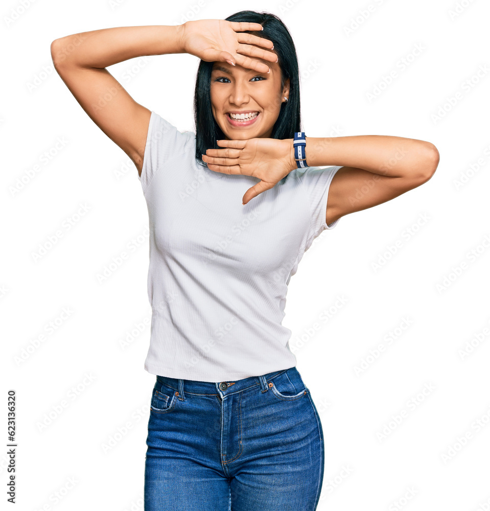 Beautiful hispanic woman wearing casual white tshirt smiling cheerful playing peek a boo with hands showing face. surprised and exited Beautiful hispanic woman wearing casual white tshirt smiling cheerful playing peek a boo with hands showing face. surprised and exited