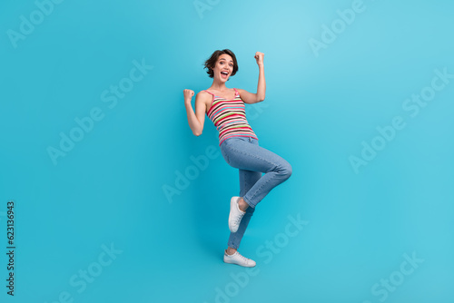 Fototapeta Naklejka Na Ścianę i Meble -  Full length portrait of overjoyed glad person raise fists luck triumph accomplishment isolated on blue color background