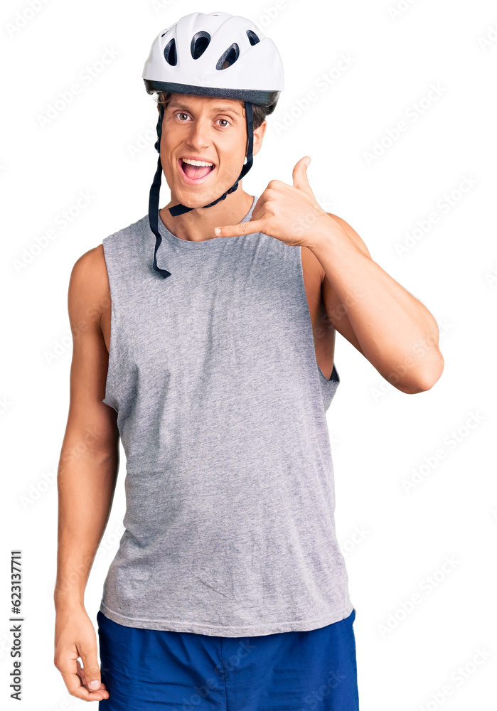 Young handsome man wearing bike helmet smiling doing phone gesture with hand and fingers like talking on the telephone. communicating concepts. Young handsome man wearing bike helmet smiling doing phone gesture with hand and fingers like talking on the telephone. communicating concepts.