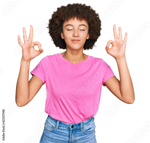 Young hispanic girl wearing casual clothes relax and smiling with eyes closed doing meditation gesture with fingers. yoga concept.
