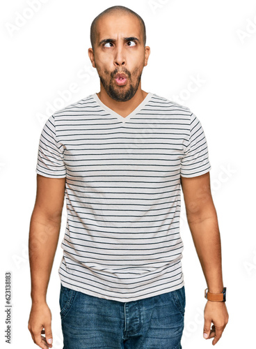 Hispanic adult man wearing casual clothes making fish face with lips, crazy and comical gesture. funny expression.