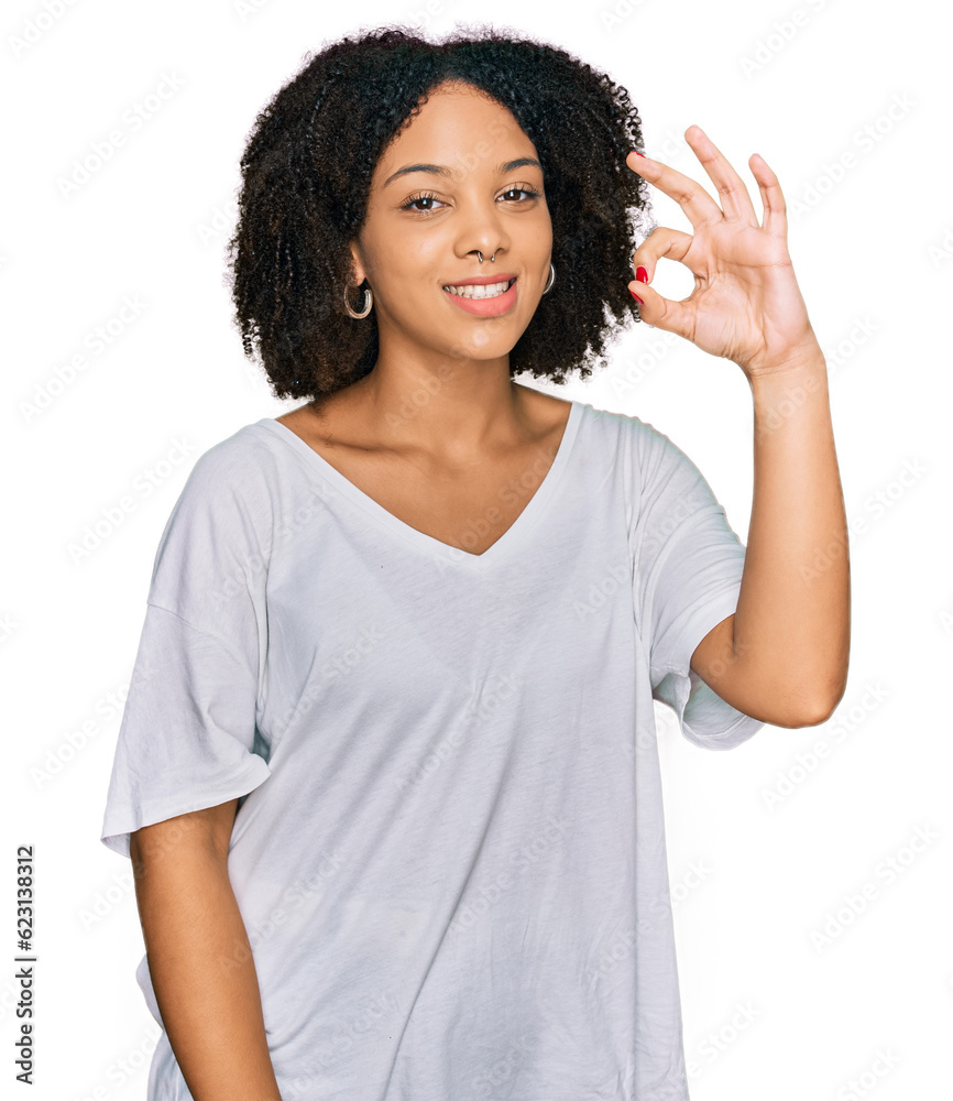 Young african american girl wearing casual clothes smiling positive doing ok sign with hand and fingers. successful expression. Young african american girl wearing casual clothes smiling positive doing ok sign with hand and fingers. successful expression.