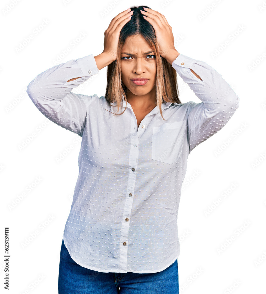 Young hispanic woman wearing casual white shirt suffering from headache desperate and stressed because pain and migraine. hands on head. Young hispanic woman wearing casual white shirt suffering from headache desperate and stressed because pain and migraine. hands on head.