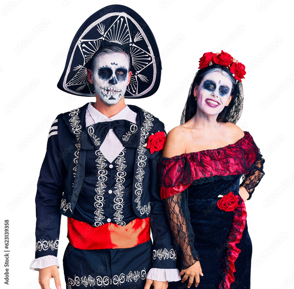Young couple wearing mexican day of the dead costume over background winking looking at the camera with sexy expression, cheerful and happy face. Young couple wearing mexican day of the dead costume over background winking looking at the camera with sexy expression, cheerful and happy face.
