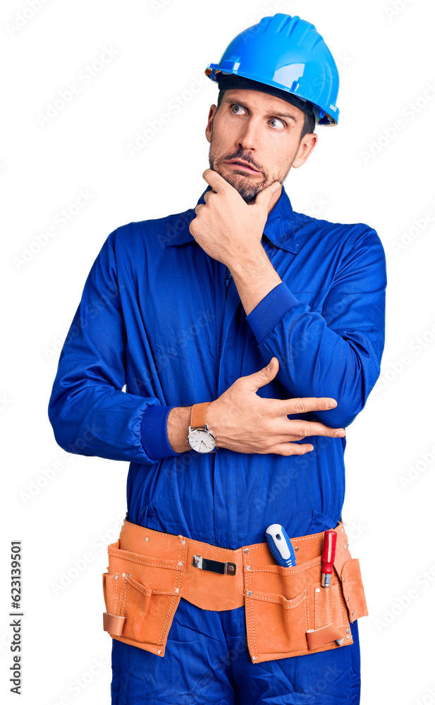 Young handsome man wearing worker uniform and hardhat pointing aside worried and nervous with forefinger, concerned and surprised expression Young handsome man wearing worker uniform and hardhat pointing aside worried and nervous with forefinger, concerned and surprised expression