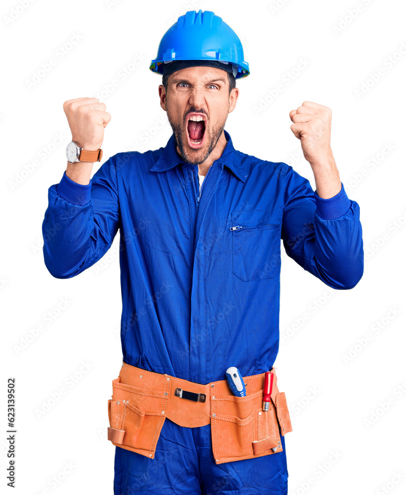 Young handsome man wearing worker uniform and hardhat pointing displeased and frustrated to the camera, angry and furious with you