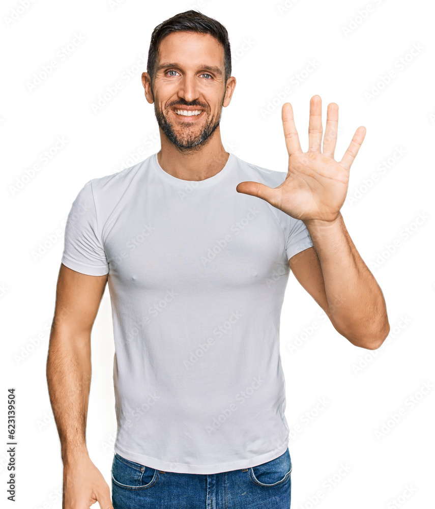 Handsome man with beard wearing casual white t shirt showing and pointing up with fingers number five while smiling confident and happy. Handsome man with beard wearing casual white t shirt showing and pointing up with fingers number five while smiling confident and happy.