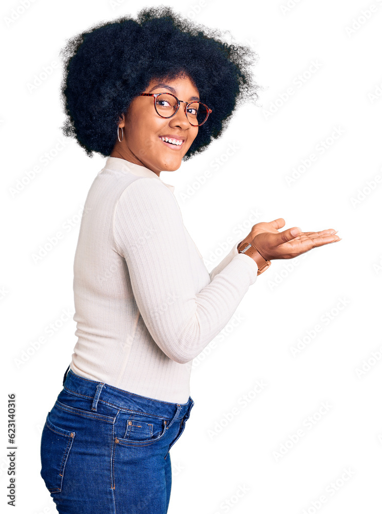 Young african american girl wearing casual clothes and glasses pointing aside with hands open palms showing copy space, presenting advertisement smiling excited happy Young african american girl wearing casual clothes and glasses pointing aside with hands open palms showing copy space, presenting advertisement smiling excited happy