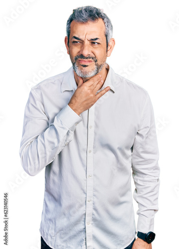 Middle age hispanic with grey hair wearing casual white shirt touching painful neck, sore throat for flu, clod and infection © Krakenimages.com