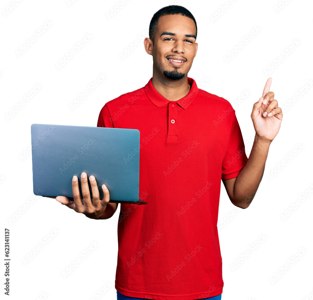 Young african american man working using computer laptop surprised with an idea or question pointing finger with happy face, number one Young african american man working using computer laptop surprised with an idea or question pointing finger with happy face, number one