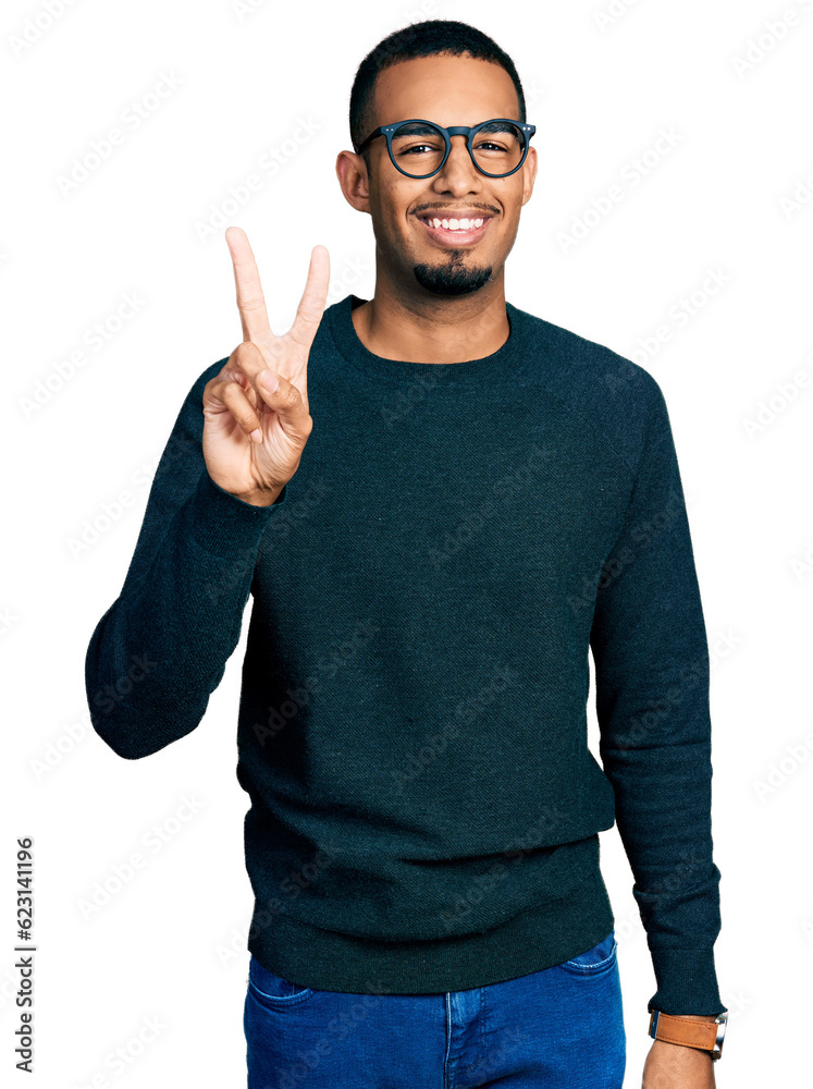 Naklejka premium Young african american man wearing casual clothes and glasses showing and pointing up with fingers number two while smiling confident and happy.