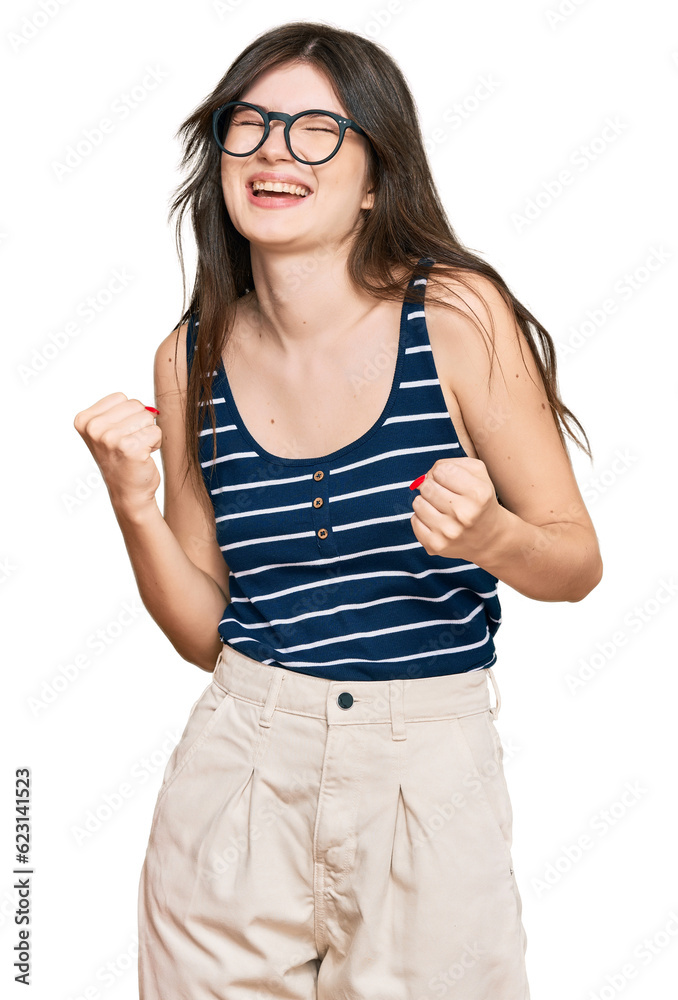 Young beautiful caucasian girl wearing casual clothes and glasses very happy and excited doing winner gesture with arms raised, smiling and screaming for success. celebration concept. Young beautiful caucasian girl wearing casual clothes and glasses very happy and excited doing winner gesture with arms raised, smiling and screaming for success. celebration concept.