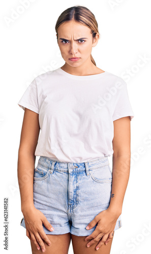 Young beautiful blonde woman wearing casual white tshirt skeptic and nervous, frowning upset because of problem. negative person.