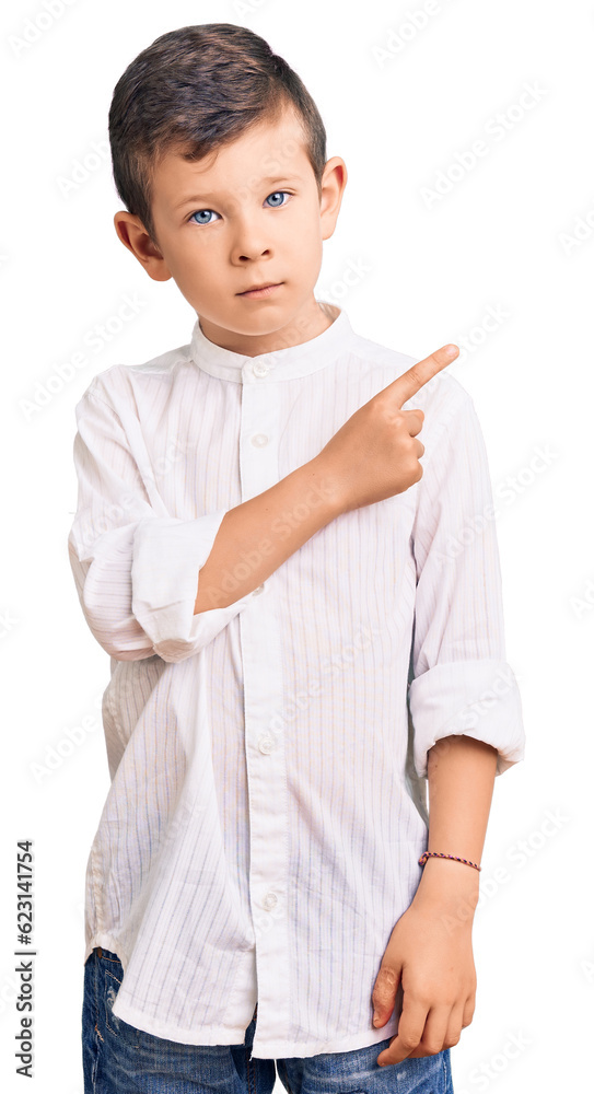 Cute blond kid wearing elegant shirt pointing with hand finger to the side showing advertisement, serious and calm face Cute blond kid wearing elegant shirt pointing with hand finger to the side showing advertisement, serious and calm face