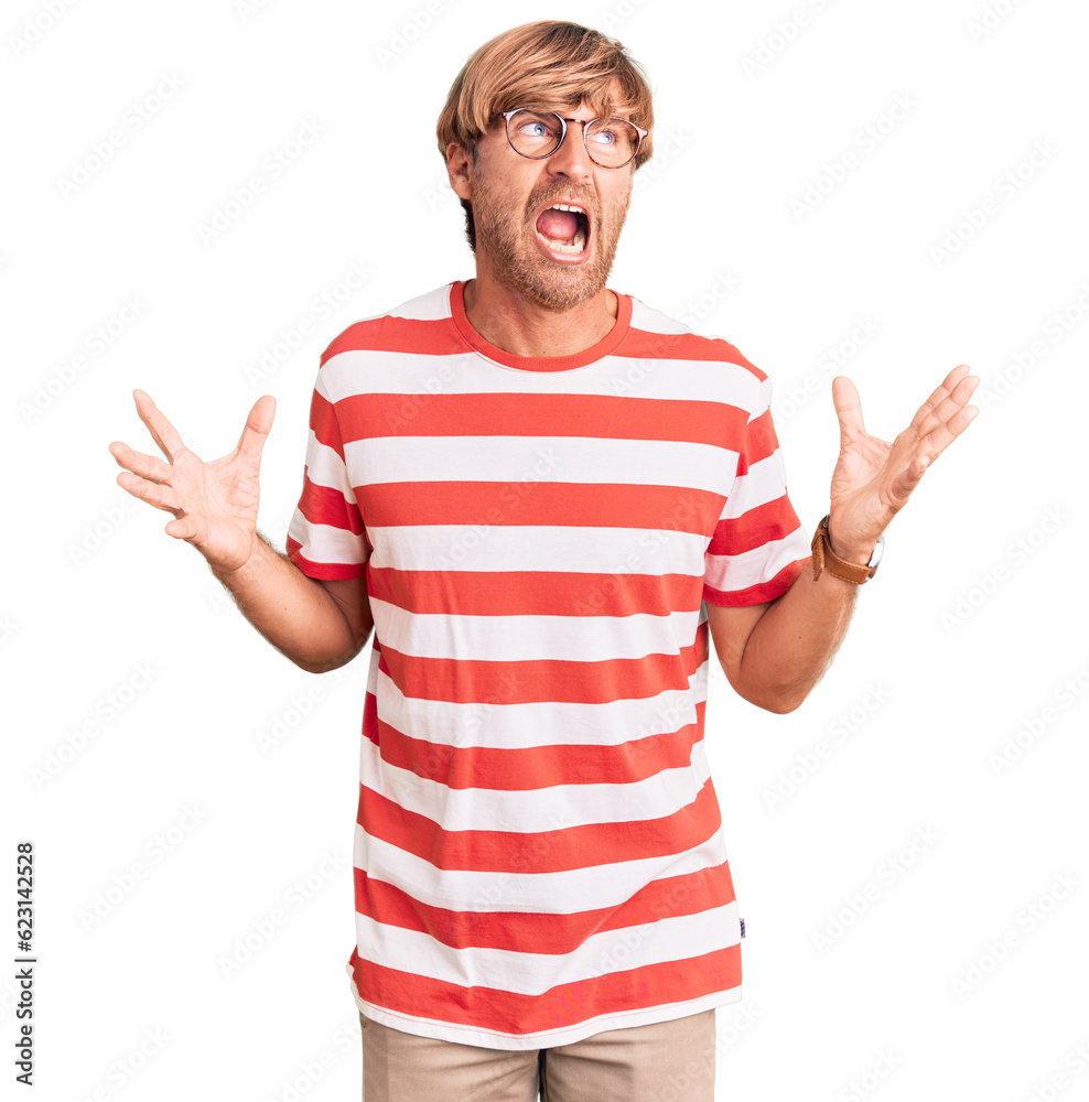 Handsome caucasian man with beard wearing casual clothes and glasses crazy and mad shouting and yelling with aggressive expression and arms raised. frustration concept. Handsome caucasian man with beard wearing casual clothes and glasses crazy and mad shouting and yelling with aggressive expression and arms raised. frustration concept.