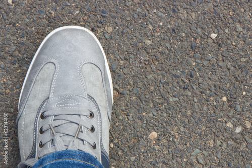 Gray leather shoes on asphalt road or footpath. Male footwear. Copy space for text