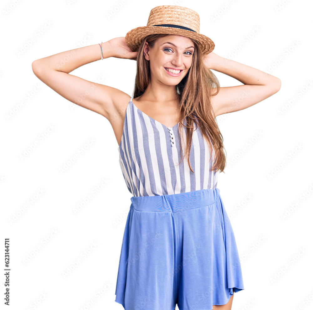 Young beautiful blonde woman wearing summer hat relaxing and stretching, arms and hands behind head and neck smiling happy Young beautiful blonde woman wearing summer hat relaxing and stretching, arms and hands behind head and neck smiling happy