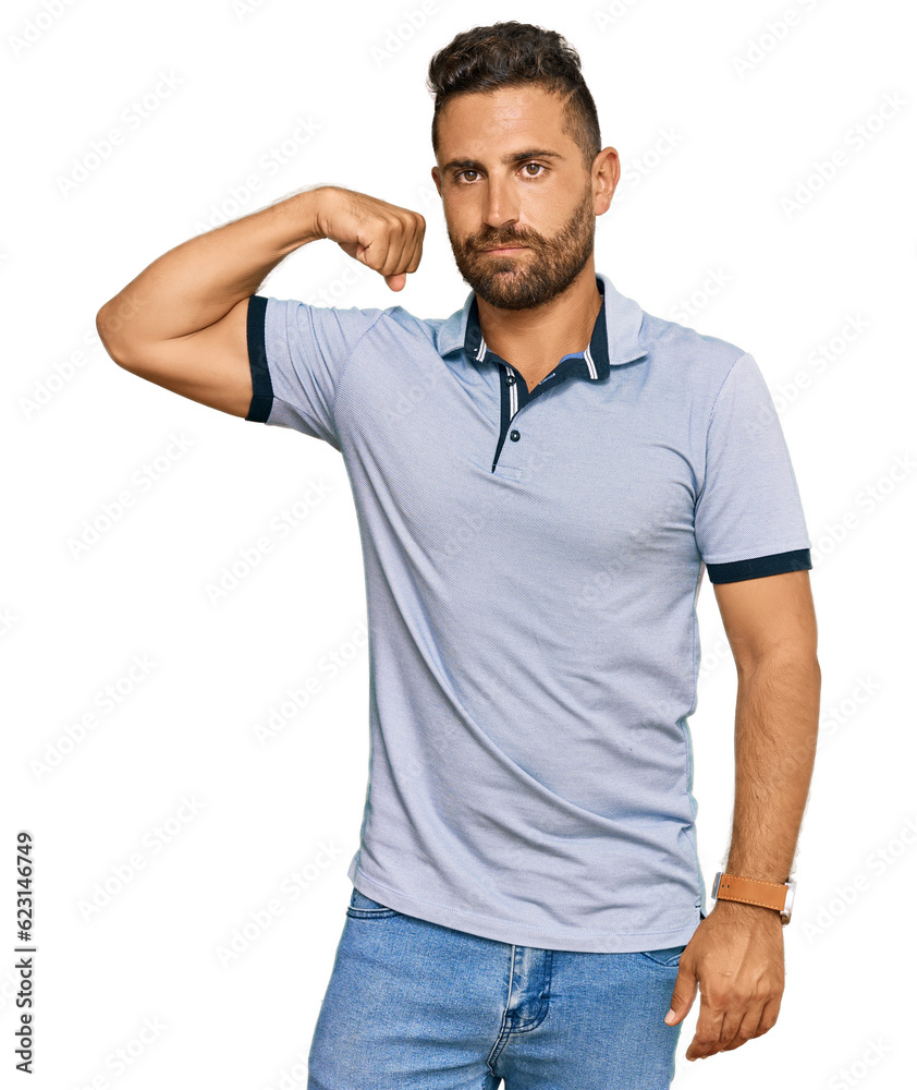 Handsome man with beard wearing casual clothes strong person showing arm muscle, confident and proud of power Handsome man with beard wearing casual clothes strong person showing arm muscle, confident and proud of power