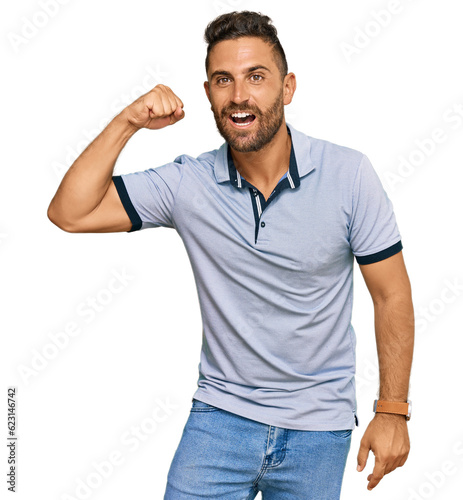 Handsome man with beard wearing casual clothes angry and mad raising fist frustrated and furious while shouting with anger. rage and aggressive concept.