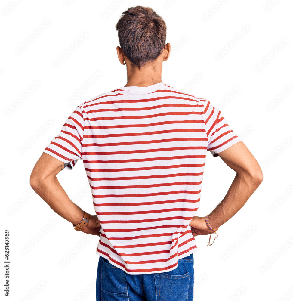 Handsome blond man with beard wearing casual clothes and glasses standing backwards looking away with arms on body Handsome blond man with beard wearing casual clothes and glasses standing backwards looking away with arms on body