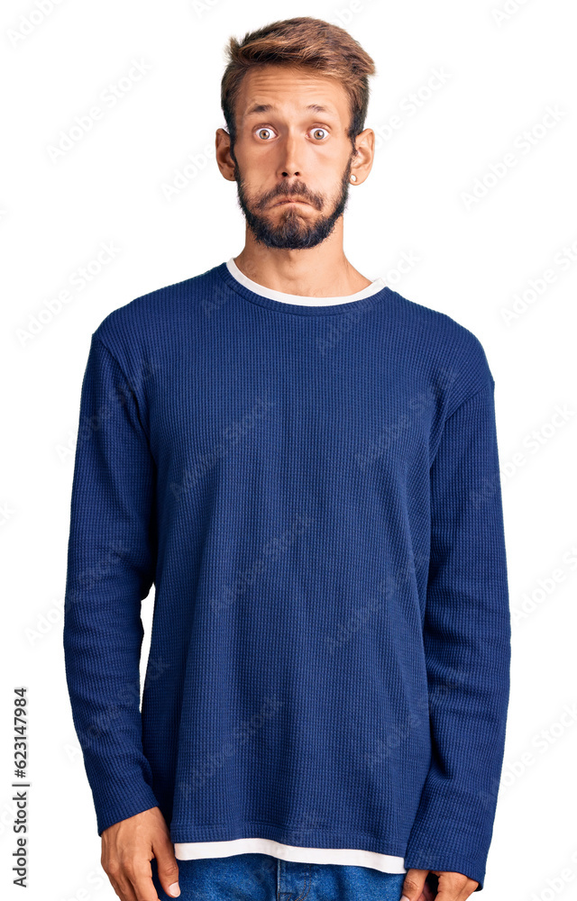 Handsome blond man with beard wearing casual sweater puffing cheeks with funny face. mouth inflated with air, crazy expression. Handsome blond man with beard wearing casual sweater puffing cheeks with funny face. mouth inflated with air, crazy expression.