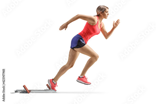 Full length profile shot of a female athlete on starting blocks starting a run