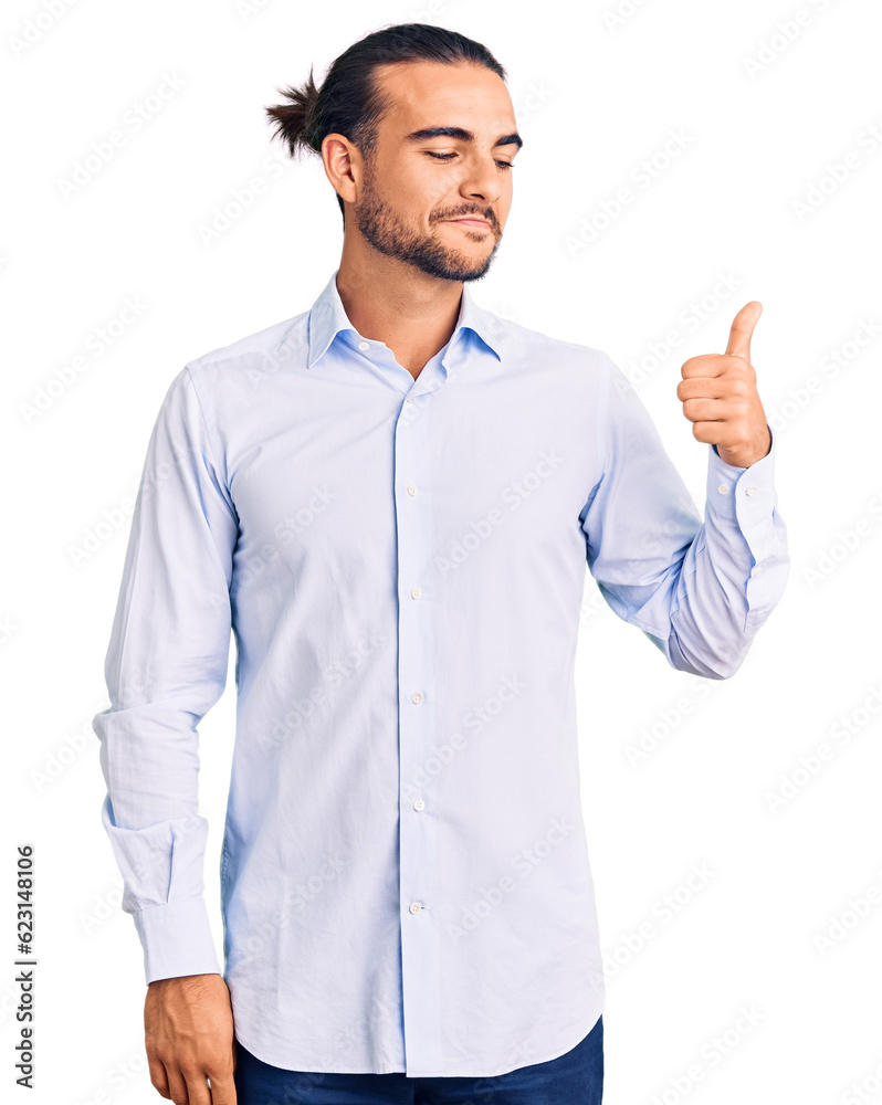 Young handsome man wearing business clothes looking proud, smiling doing thumbs up gesture to the side Young handsome man wearing business clothes looking proud, smiling doing thumbs up gesture to the side