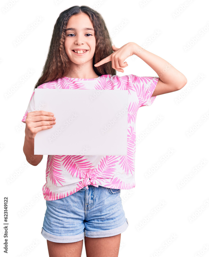 Cute hispanic child girl holding blank empty banner pointing finger to one self smiling happy and proud Cute hispanic child girl holding blank empty banner pointing finger to one self smiling happy and proud