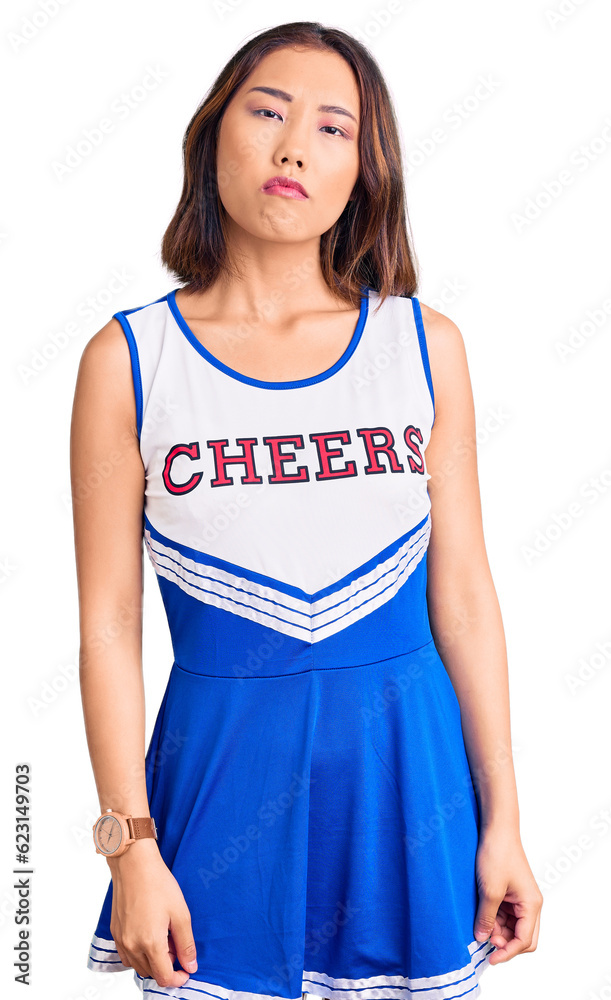 Young beautiful chinese girl wearing cheerleader uniform skeptic and nervous, frowning upset because of problem. negative person. Young beautiful chinese girl wearing cheerleader uniform skeptic and nervous, frowning upset because of problem. negative person.