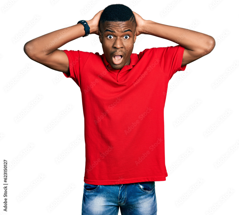 Young african american man wearing casual red t shirt crazy and scared with hands on head, afraid and surprised of shock with open mouth Young african american man wearing casual red t shirt crazy and scared with hands on head, afraid and surprised of shock with open mouth