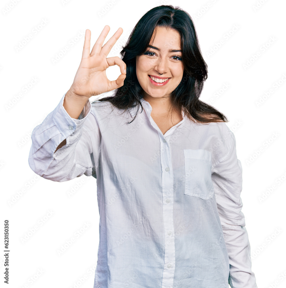 Beautiful hispanic woman wearing casual white shirt smiling positive doing ok sign with hand and fingers. successful expression. Beautiful hispanic woman wearing casual white shirt smiling positive doing ok sign with hand and fingers. successful expression.