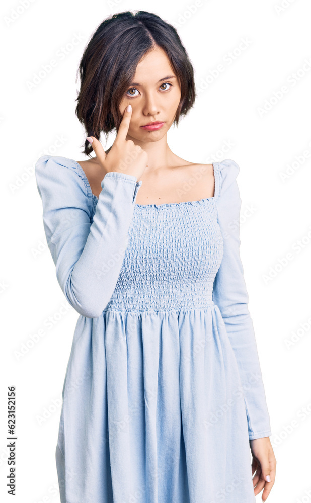 Young beautiful girl wearing casual clothes pointing to the eye watching you gesture, suspicious expression Young beautiful girl wearing casual clothes pointing to the eye watching you gesture, suspicious expression