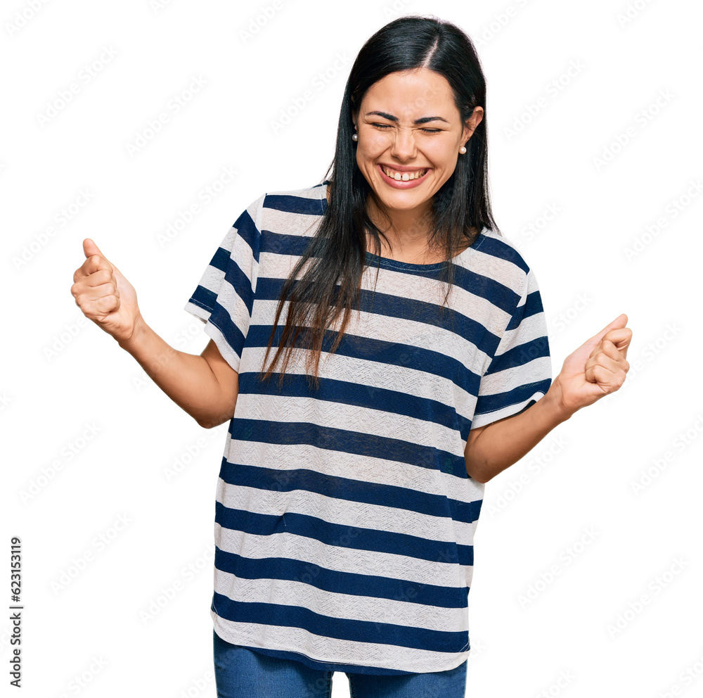 Beautiful young woman wearing casual clothes very happy and excited doing winner gesture with arms raised, smiling and screaming for success. celebration concept.
