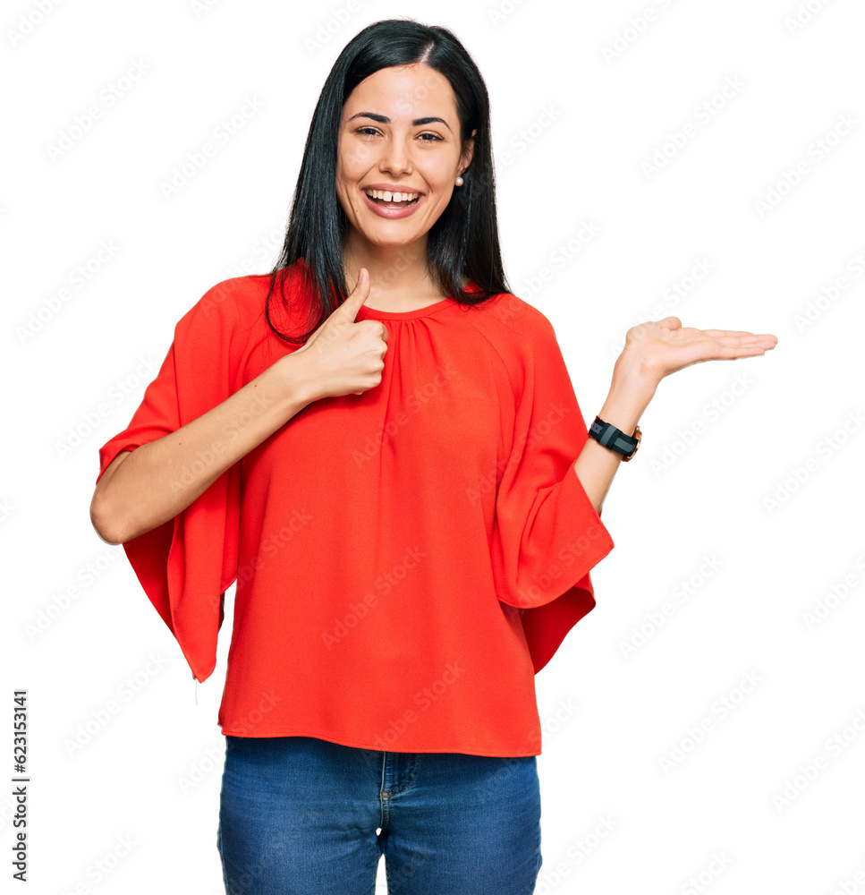 Beautiful young woman wearing casual clothes showing palm hand and doing ok gesture with thumbs up, smiling happy and cheerful Beautiful young woman wearing casual clothes showing palm hand and doing ok gesture with thumbs up, smiling happy and cheerful