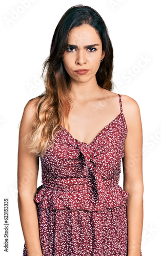 Beautiful hispanic woman wearing summer dress skeptic and nervous, frowning upset because of problem. negative person.