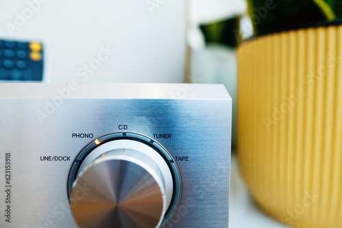 Aluminum front panel of a hi-fi audio device. Close-up of knobs, volume tuner, tape, phono line. Musical and creative setting. photo