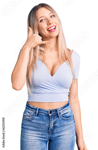 Young beautiful blonde woman wearing casual clothes smiling doing phone gesture with hand and fingers like talking on the telephone. communicating concepts.
