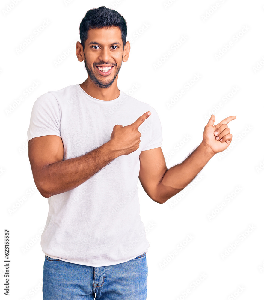 Young latin man wearing casual clothes smiling and looking at the camera pointing with two hands and fingers to the side. Young latin man wearing casual clothes smiling and looking at the camera pointing with two hands and fingers to the side.