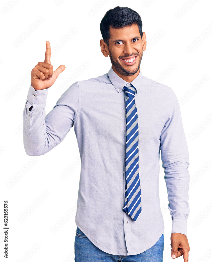 Young latin man wearing business clothes pointing finger up with successful idea. exited and happy. number one. Young latin man wearing business clothes pointing finger up with successful idea. exited and happy. number one.