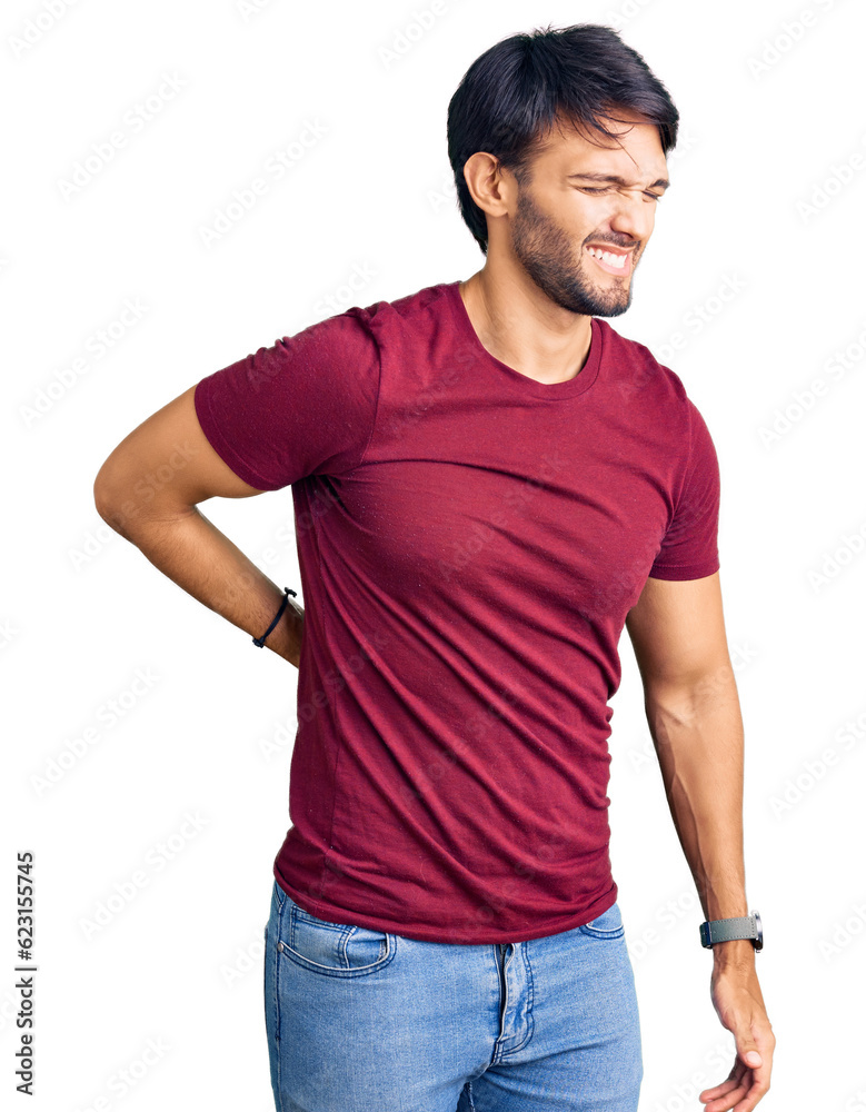 Handsome hispanic man wearing casual clothes suffering of backache, touching back with hand, muscular pain Handsome hispanic man wearing casual clothes suffering of backache, touching back with hand, muscular pain