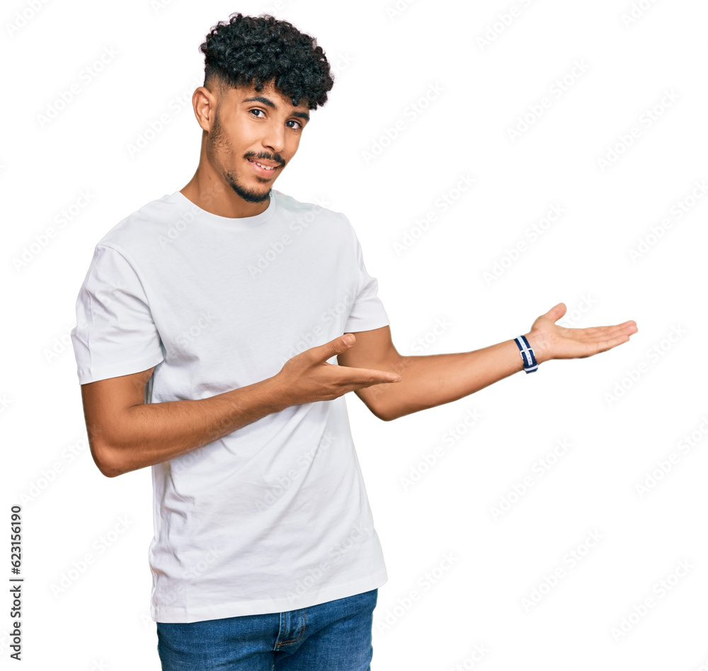 Young arab man wearing casual white t shirt inviting to enter smiling natural with open hand Young arab man wearing casual white t shirt inviting to enter smiling natural with open hand